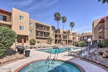 view of swimming pool featuring a hot tub and a patio