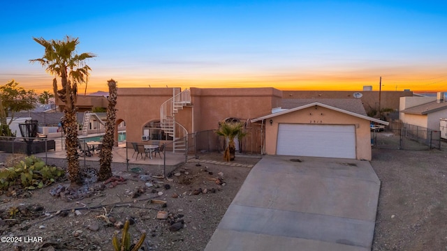 view of front of property featuring a garage and a patio area