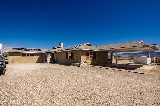 rear view of house with a storage shed and solar panels