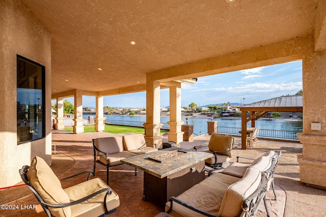 view of patio / terrace with a water view, a gazebo, and an outdoor living space with a fire pit