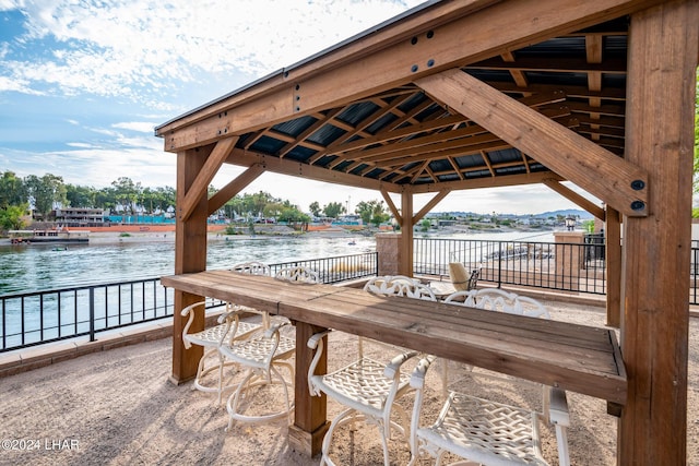 view of dock featuring a water view, an outdoor bar, and a gazebo