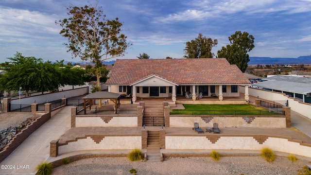 view of front facade with a gazebo, a mountain view, and a patio