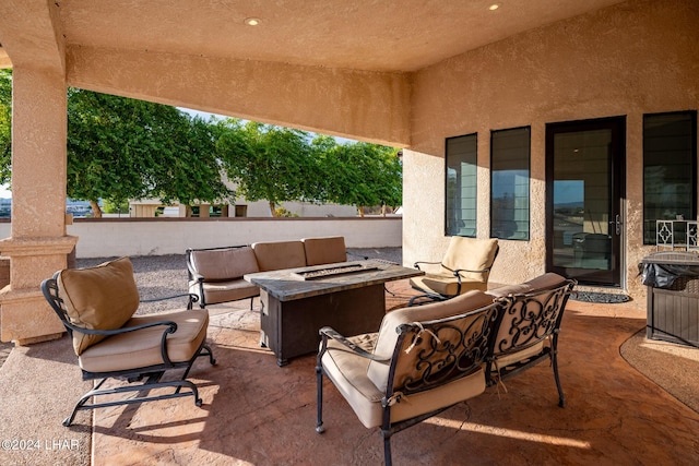 view of patio with an outdoor living space with a fire pit