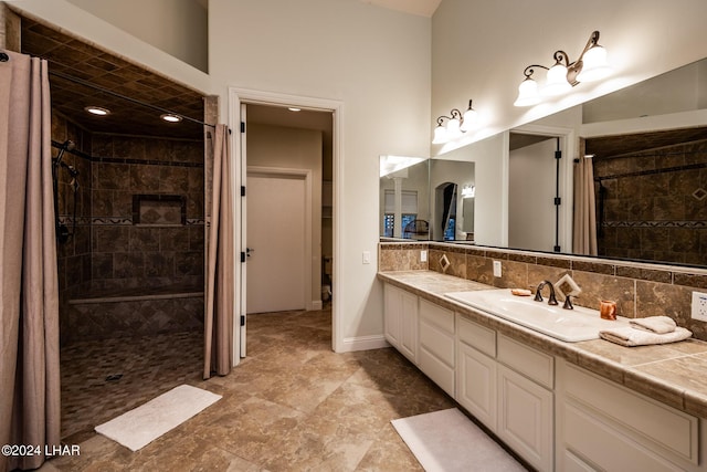 bathroom featuring tasteful backsplash, vanity, and a tile shower