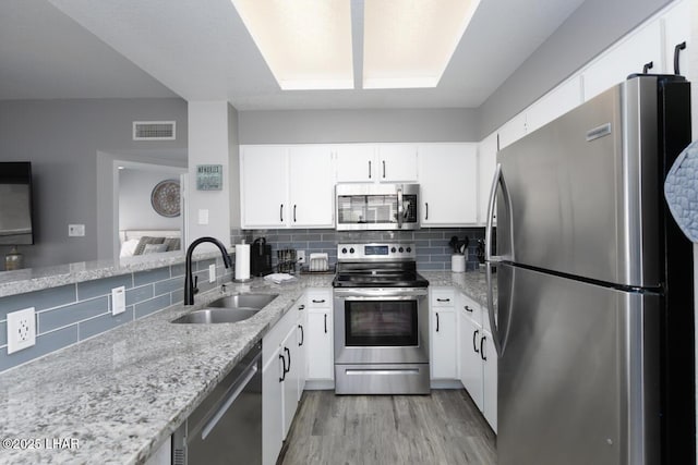 1650 Smoketree Ave S Unit 135, Avenue, Lake Havasu City, AZ 86403 - kitchen with appliances with stainless steel finishes, a sink, light wood-style flooring, backsplash, and light stone countertops