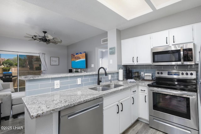 1650 Smoketree Ave S Unit 135, Avenue, Lake Havasu City, AZ 86403 - kitchen featuring stainless steel appliances, a sink, light wood-style floors, backsplash, and light stone counters