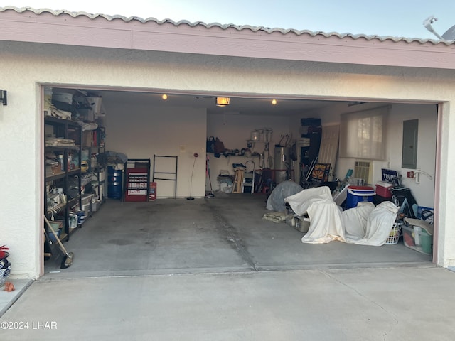 garage featuring a garage door opener, electric panel, and water heater