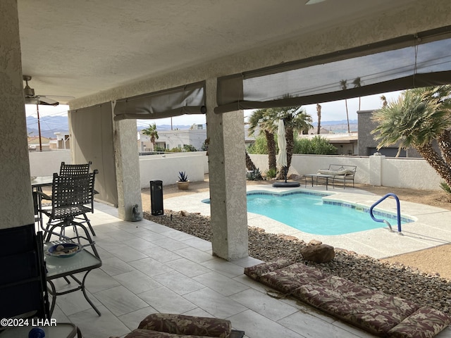 view of swimming pool with a mountain view, ceiling fan, and a patio area