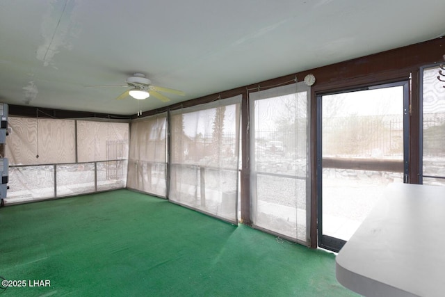 unfurnished sunroom with ceiling fan