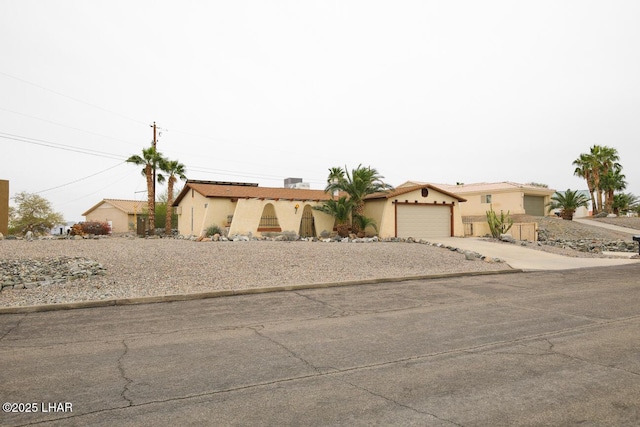 view of front of property featuring concrete driveway, an attached garage, and stucco siding