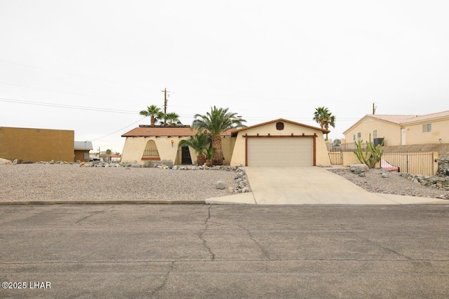 view of front facade with concrete driveway, an attached garage, fence, and stucco siding