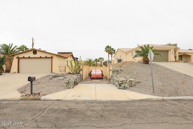 view of front of property featuring stucco siding, fence, driveway, and a gate