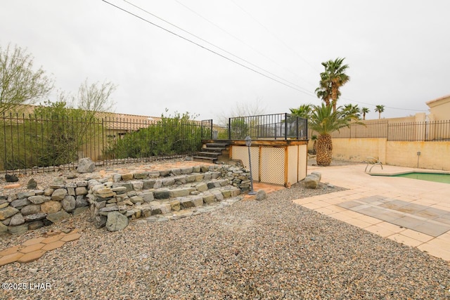 view of yard with a wooden deck, a patio, a fenced backyard, and stairs