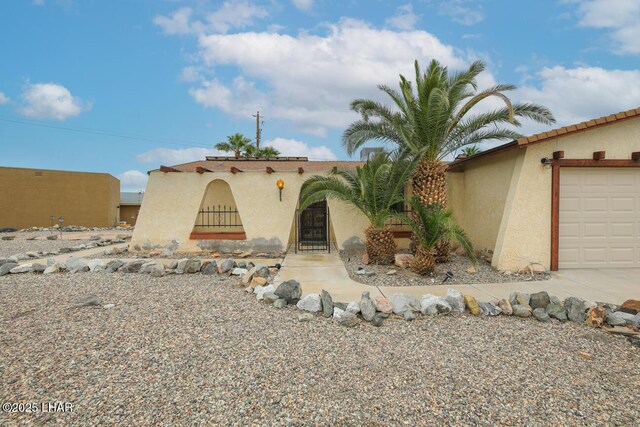 mediterranean / spanish-style home featuring an attached garage and stucco siding