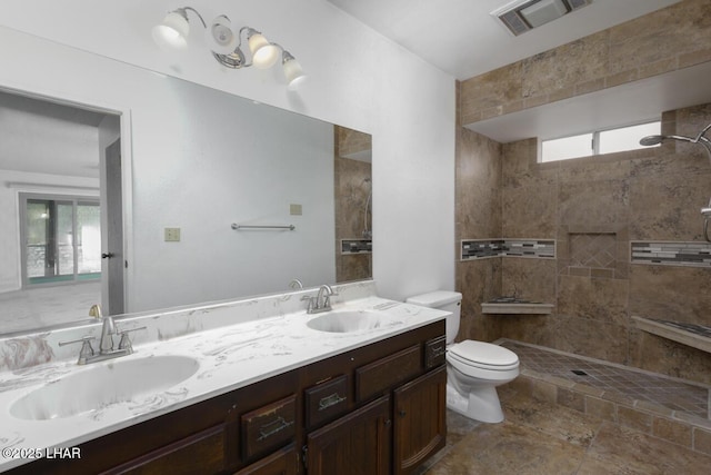 full bathroom featuring toilet, visible vents, a wealth of natural light, and a sink