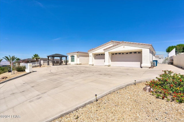 view of front of property featuring a garage and a gazebo