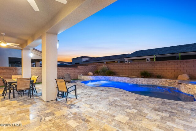 pool at dusk with a patio, ceiling fan, and an in ground hot tub