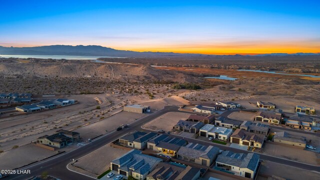 aerial view at dusk featuring a mountain view