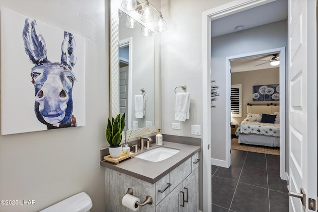 bathroom featuring tile patterned flooring, vanity, ceiling fan, and toilet