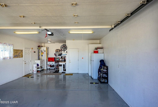 garage featuring white refrigerator and a garage door opener