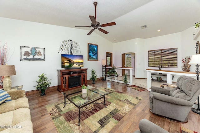 living room featuring hardwood / wood-style floors, vaulted ceiling, a textured ceiling, and ceiling fan