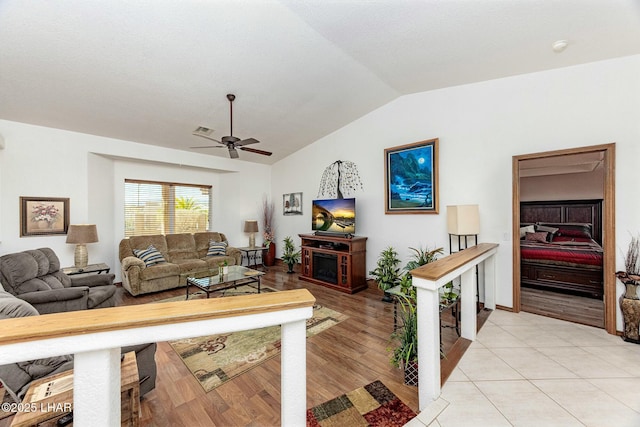 tiled living room with ceiling fan and lofted ceiling