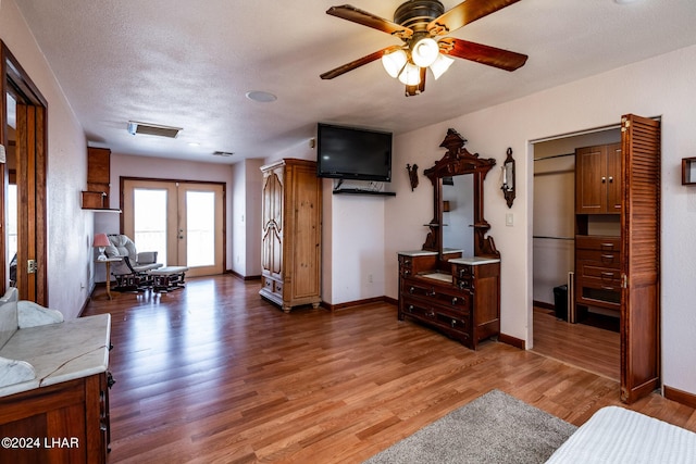 interior space with ceiling fan, dark wood-type flooring, a textured ceiling, and french doors