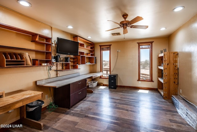 office featuring ceiling fan, built in desk, and dark hardwood / wood-style flooring