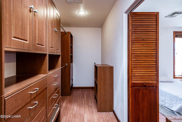 walk in closet with light wood-type flooring