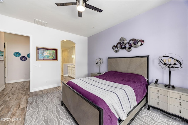2800 Papeete Dr, Lake Havasu City, AZ 86404 - bedroom with baseboards, connected bathroom, visible vents, arched walkways, and wood finished floors