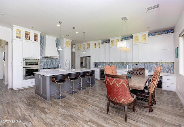 2800 Papeete Dr, Lake Havasu City, AZ 86404 - kitchen featuring visible vents, light countertops, appliances with stainless steel finishes, premium range hood, and an island with sink