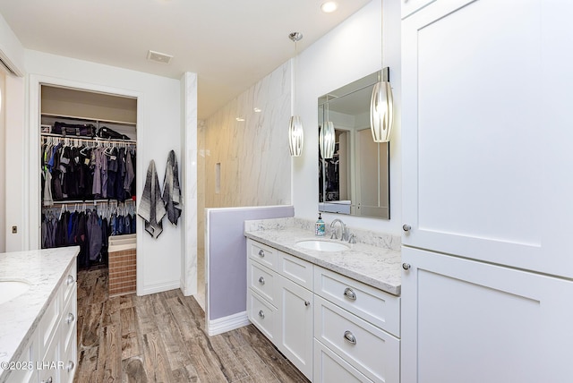 2800 Papeete Dr, Lake Havasu City, AZ 86404 - full bathroom featuring two vanities, a spacious closet, visible vents, wood finished floors, and a sink