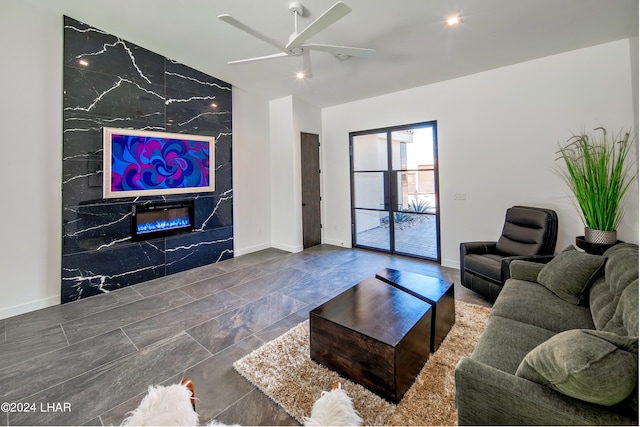living room featuring ceiling fan, a premium fireplace, and baseboards