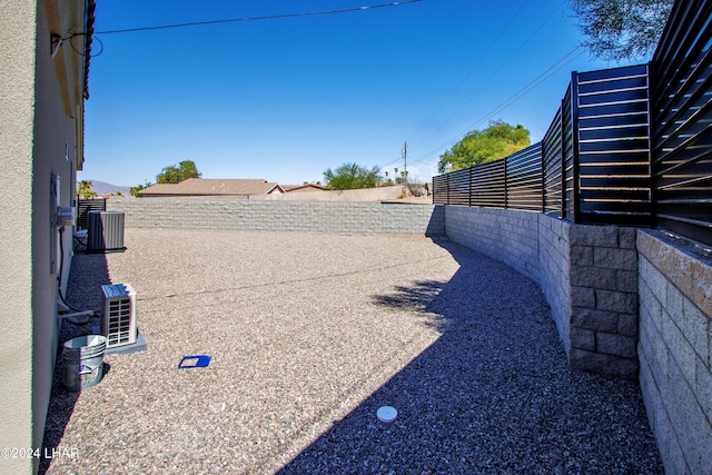 view of yard featuring a fenced backyard and central AC