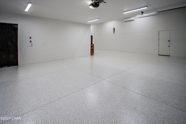 garage with a wall mounted air conditioner and a garage door opener