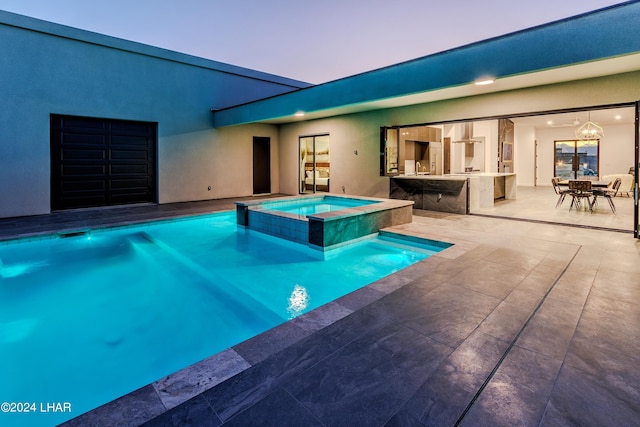 view of pool with a pool with connected hot tub, a patio, outdoor dry bar, and an outdoor kitchen