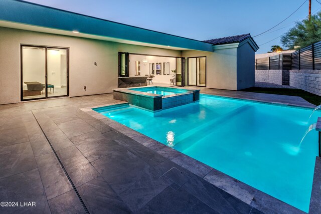 view of swimming pool featuring a pool with connected hot tub, a patio, and fence