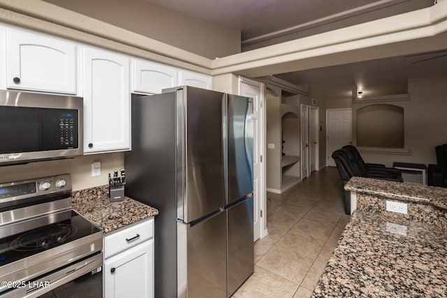 2764 Daytona Ave, Lake Havasu City, AZ 86403 - kitchen featuring open floor plan, dark stone counters, white cabinets, light tile patterned floors, and stainless steel appliances