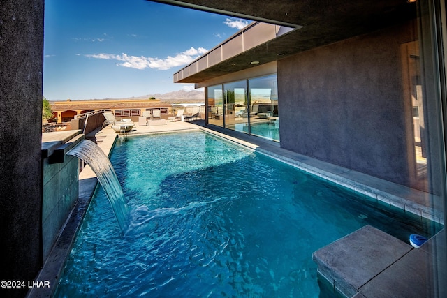 view of pool with pool water feature and a patio area