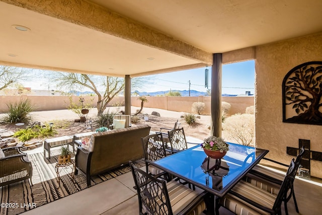 view of patio featuring a mountain view, a fenced backyard, and outdoor dining space