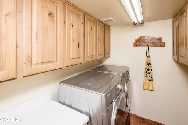 clothes washing area featuring washing machine and clothes dryer and cabinets