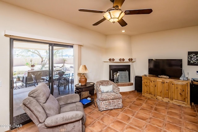 living area with recessed lighting, a fireplace with raised hearth, a ceiling fan, and light tile patterned flooring