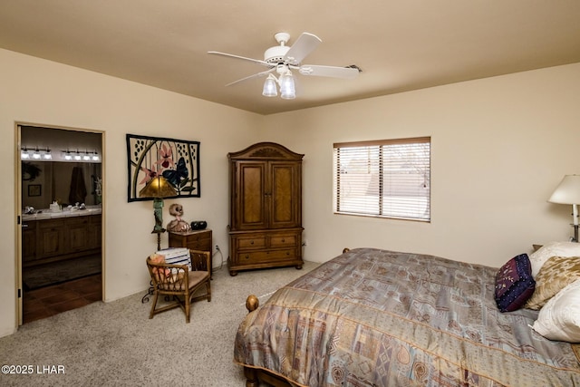 carpeted bedroom with ensuite bathroom and ceiling fan