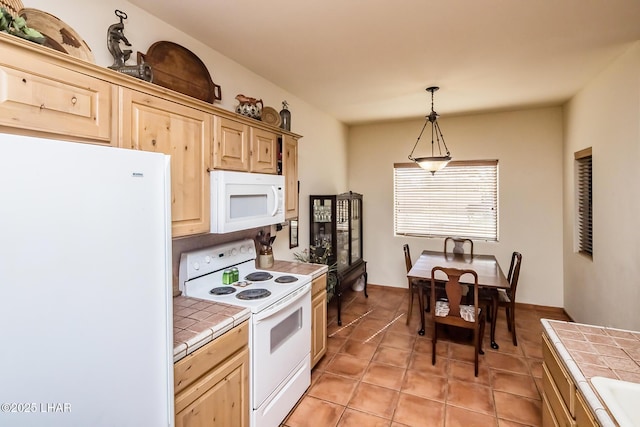 kitchen with tile counters, hanging light fixtures, white appliances, and light brown cabinets