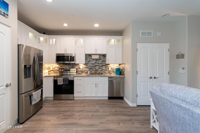 490 N Lake Havasu Ave Unit J, Lake Havasu City, AZ 86403 - kitchen featuring appliances with stainless steel finishes, a sink, tasteful backsplash, white cabinetry, and wood finished floors