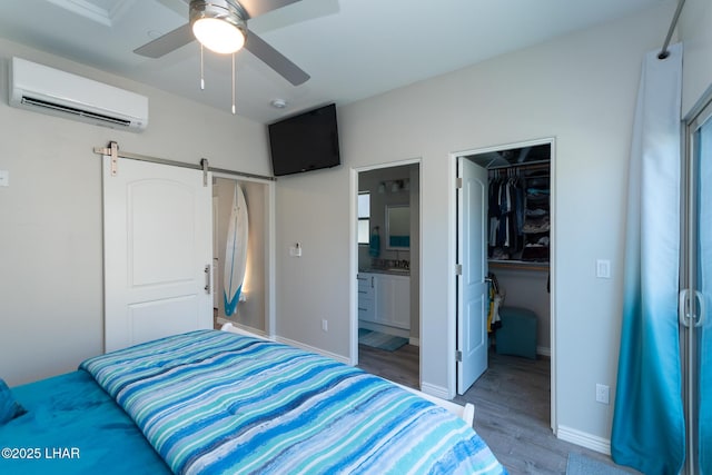490 N Lake Havasu Ave Unit J, Lake Havasu City, AZ 86403 - bedroom featuring a wall unit AC, a walk in closet, a closet, light wood-style floors, and a barn door