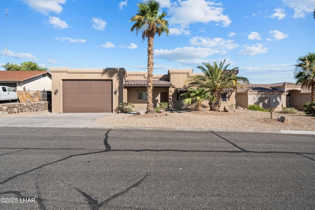 3370 Thunderhead Dr, Lake Havasu City, AZ 86406 - pueblo-style house with an attached garage, concrete driveway, stucco siding, and a tile roof
