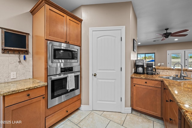 3370 Thunderhead Dr, Lake Havasu City, AZ 86406 - kitchen featuring stainless steel appliances, brown cabinetry, light stone counters, and light tile patterned floors