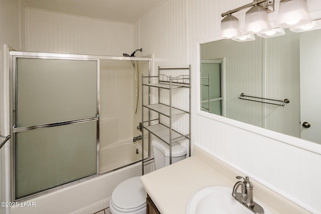 bathroom with toilet, vanity, and bath / shower combo with glass door