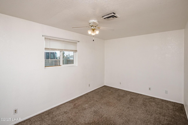 carpeted empty room featuring a textured ceiling, baseboards, visible vents, and ceiling fan